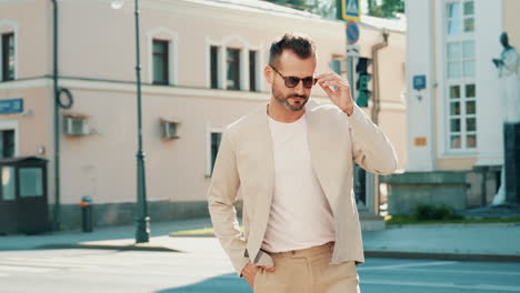 stylish man in beige outfit on city street