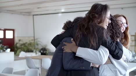 equipo de mujeres de negocios multiétnicas abrazándose en la oficina