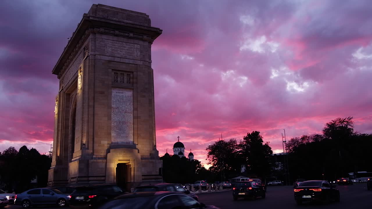 Bucharest, Romania - April 24, 2021: Cars moving near The Triumphal Arch at sunset. Vertical