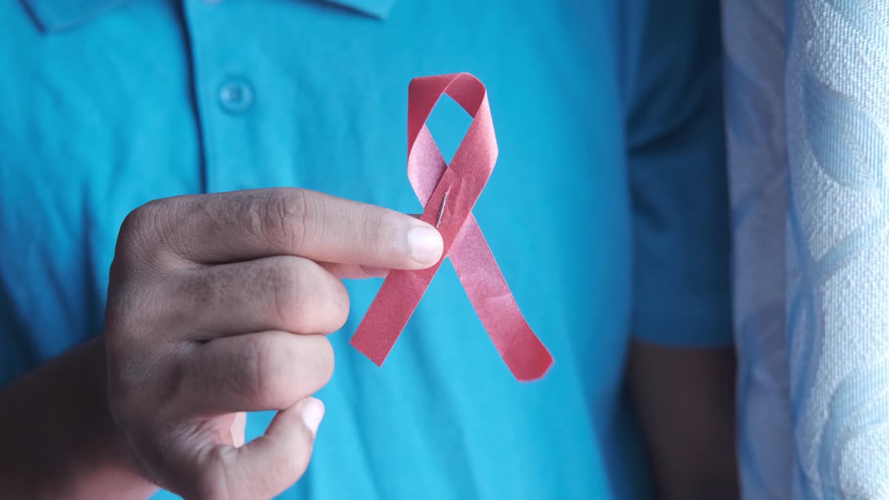 persona que sostiene una cinta rosada