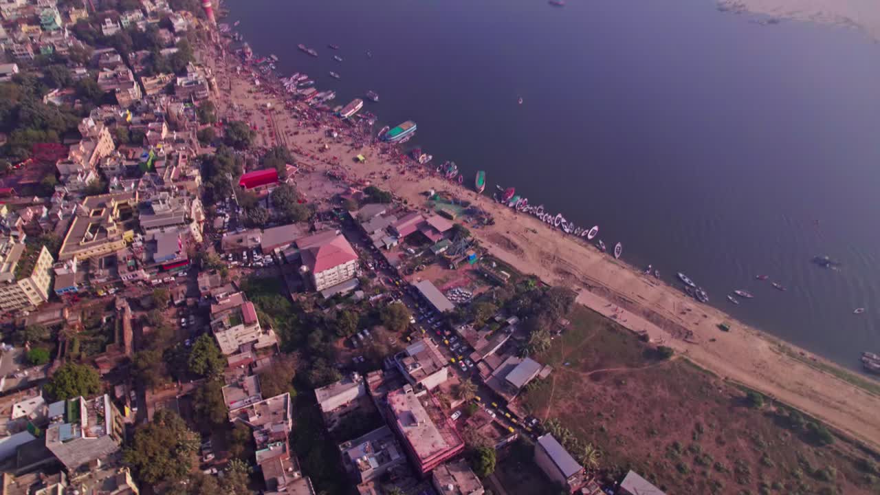 River port with buildings and parked vehicles at varanasi, banaras, kashi, uttar pradesh, india. day time, tilt down, drone shot, 4k.