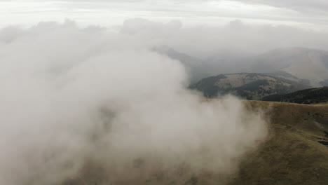 aerial shot of flying towards white cloud over autumn mountain, slovakia