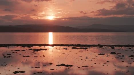 Wunderschöner-Sonnenuntergang-über-Dem-Meer,-Der-Sich-Im-Spiegelglatten-Wasser-Und-Nassen-Sand-Spiegelt