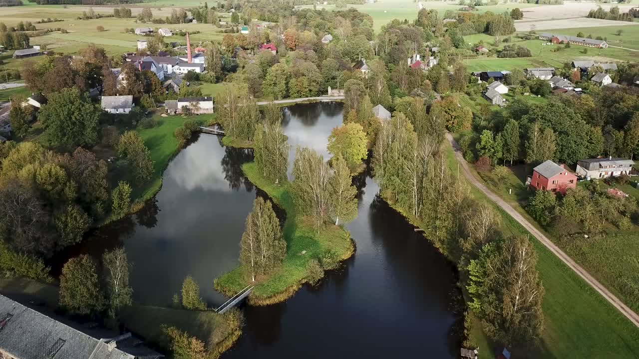Sorvolo di un lago con isole e ponti al suo interno. Villaggio verde con alberi