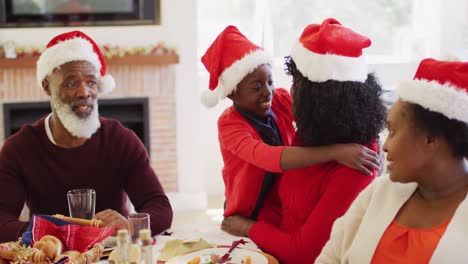 african american girl in santa hat hugging her mother