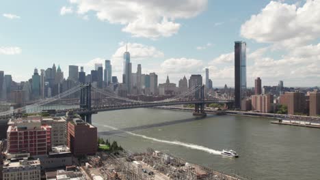 Manhattan-Bridge-in-NYC-with-a-ferry-on-the-East-River