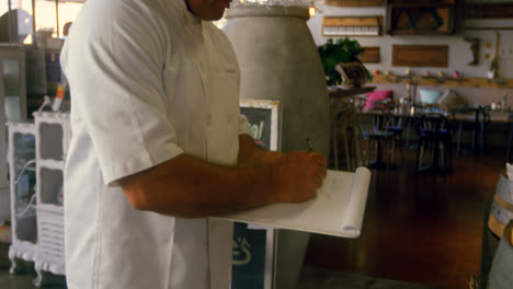 chef manteniendo registros en el bloc de notas 4k