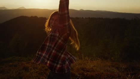 Chica-Emocionada-Bailando-En-Las-Montañas-Al-Atardecer