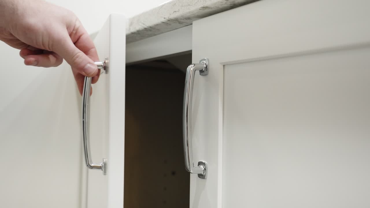 Closing a soft-close cabinet in a bathroom remodel.