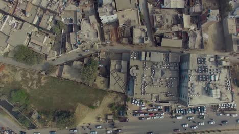bombay, india,quick aerial slide shot of an old area, showing cars moving on a road, another big road with the society