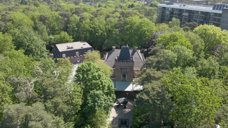 Jib-up-of-classic-manor-hidden-in-green-forest---close