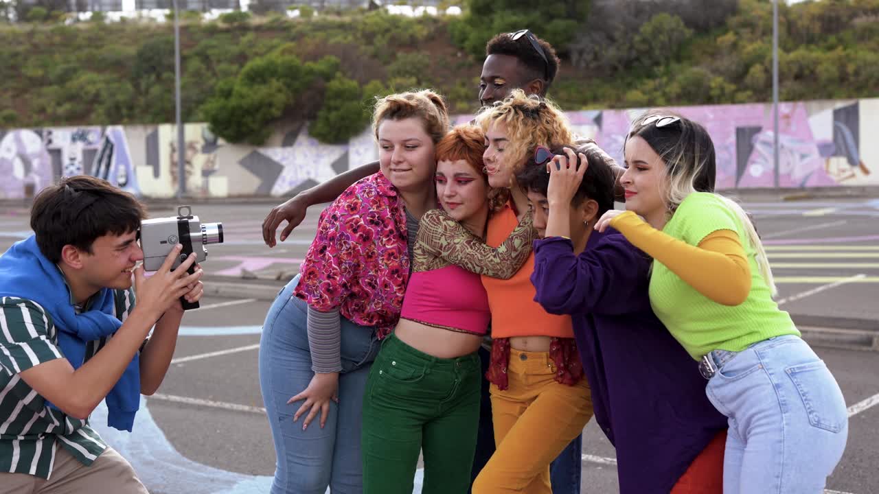 Young multiracial friends having fun using old vintage video camera outdoor