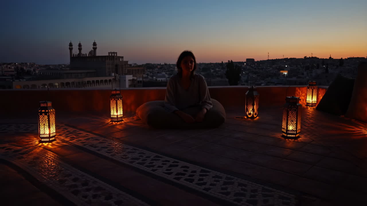 Woman relaxing on a rooftop at sunset with lanterns