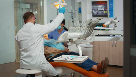 dentist treating teeth to senior woman patient in clinic