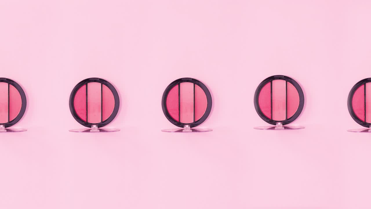 분홍색 색조를 가진 눈 그림자 패은 분홍색 배경에서 회전합니다. 움직임을 멈추십시오.