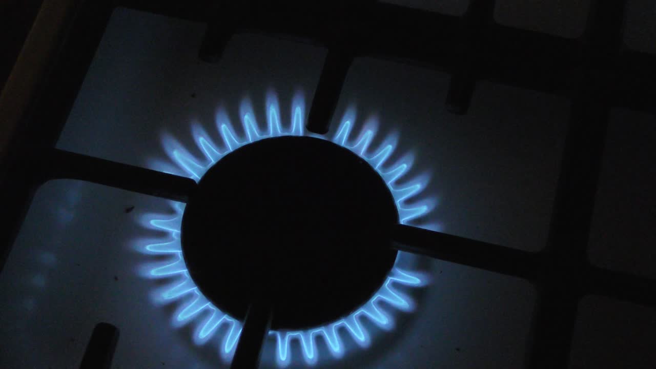 газовые горелки на плите горят в темноте.