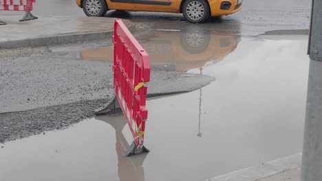 road construction with red barrier and puddle