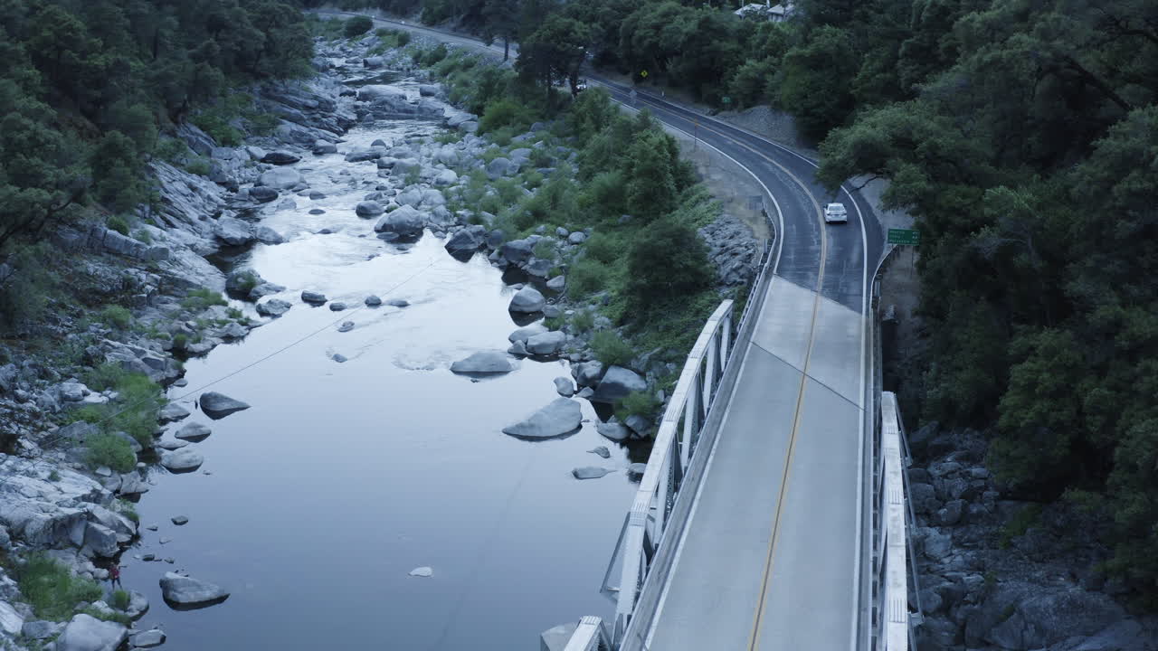 자동차는 플루마스 국유림의 협곡에 있는 작은 다리 위를 여행하며, 공중 사격