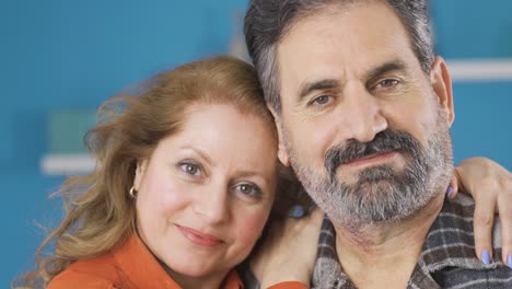 una pareja casada enamorada mirando a la cámara.