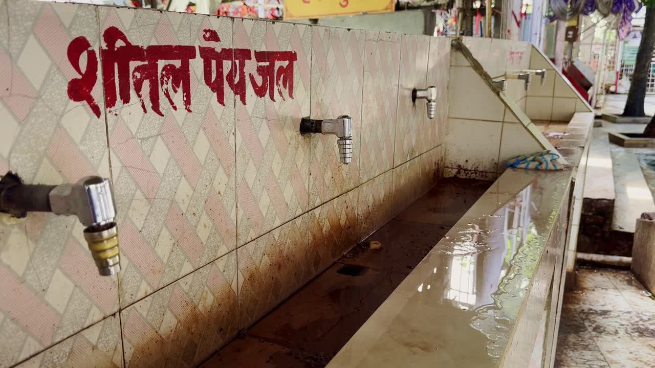 Push-in shot of taps at a drinking water facility in Maihar, Madhya Pradesh, This setup provides pilgrims with cool drinking water during their visit to the sacred Sharda Devi Temple