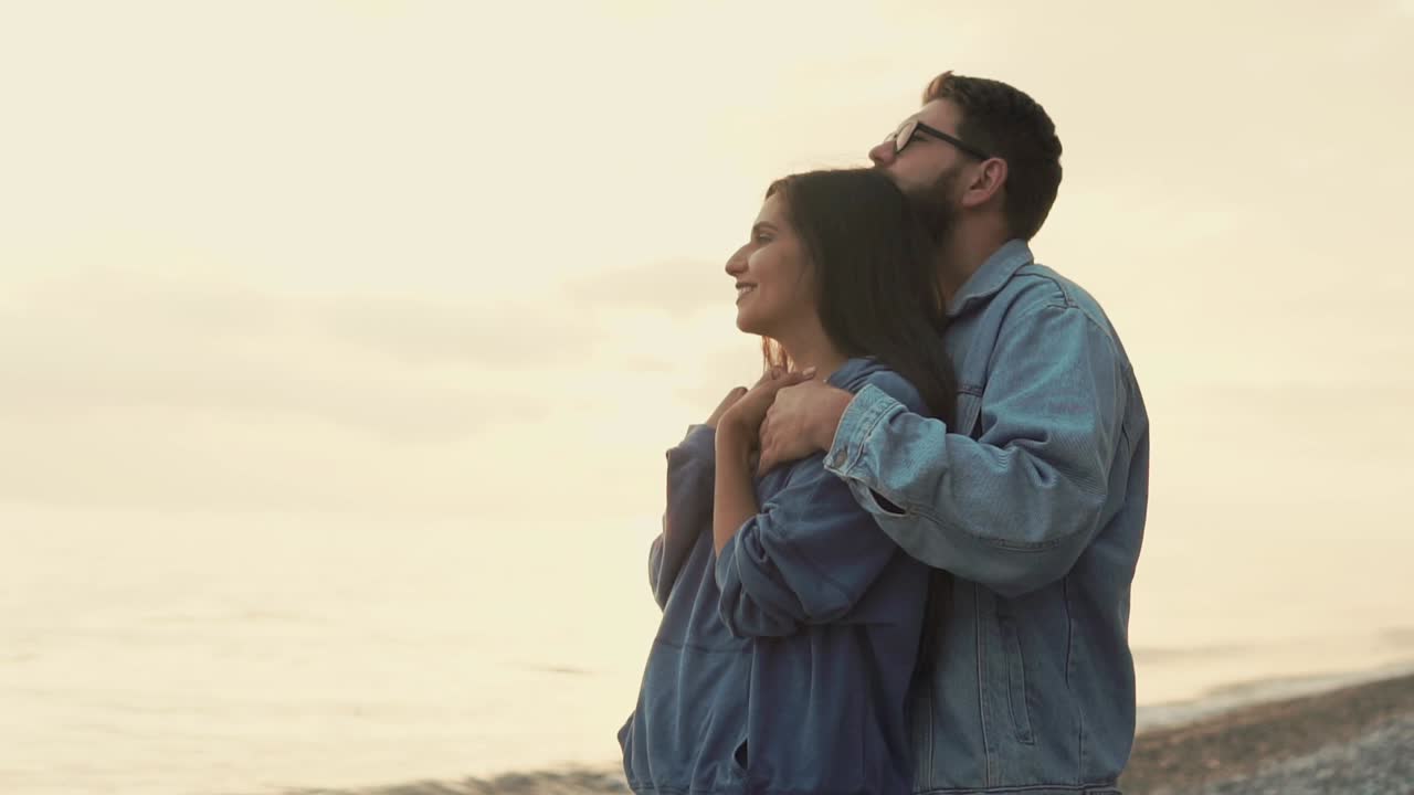 una pareja disfrutando de una puesta de sol en la playa