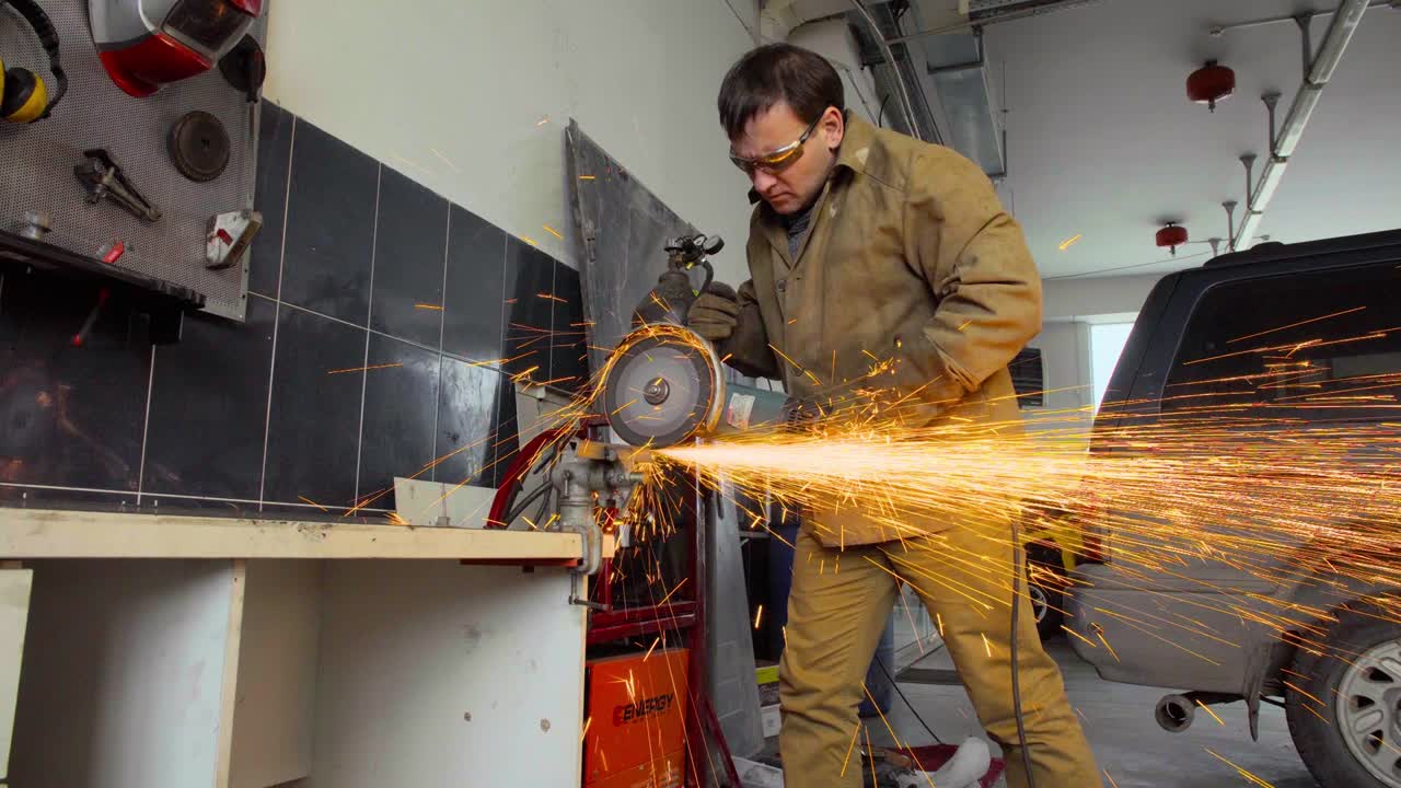 trabajador que utiliza un molinillo para cortar metal en un taller