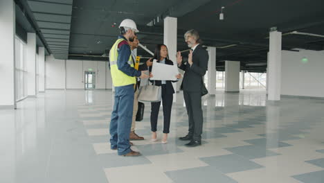 construction team reviewing plans in empty office space