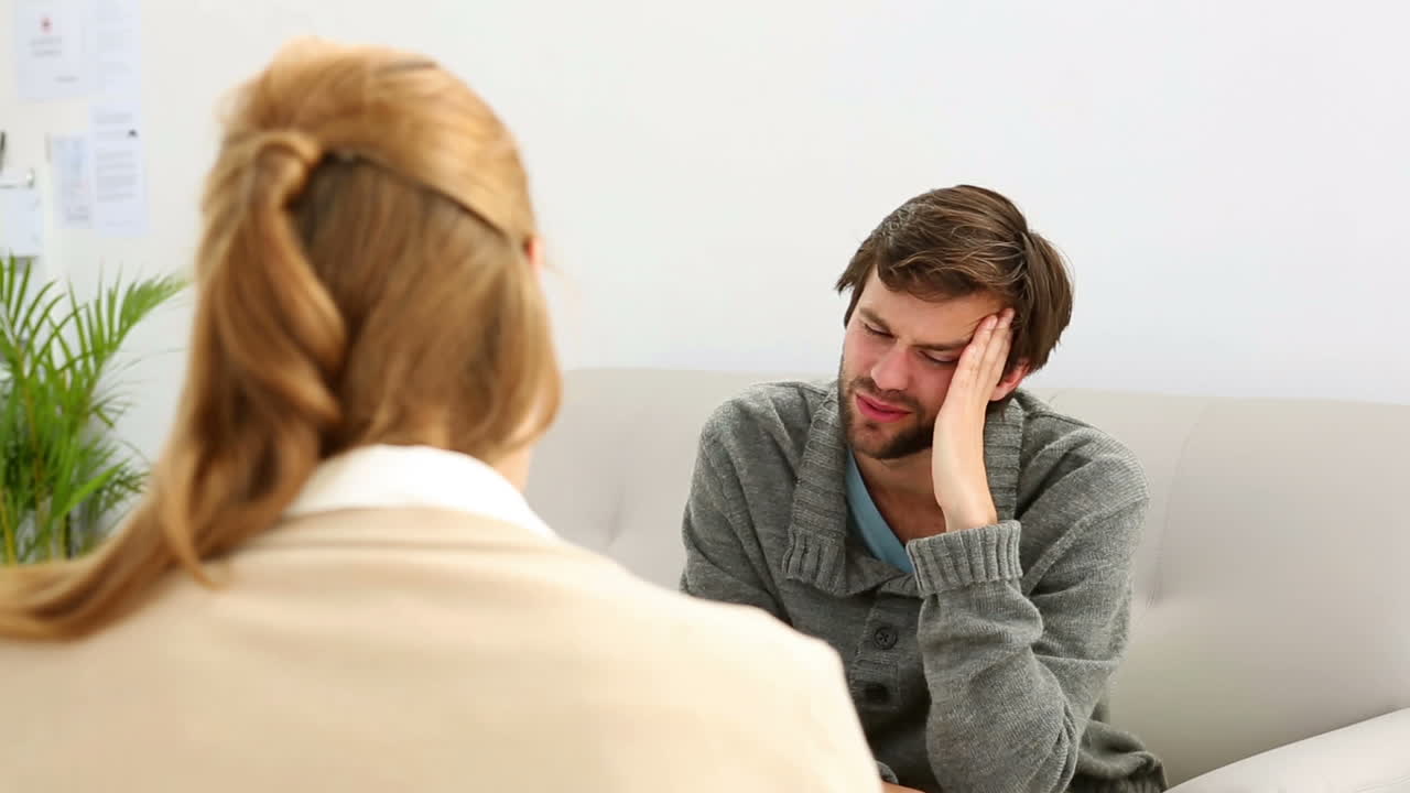 joven sentado en el sofá hablando con su terapeuta