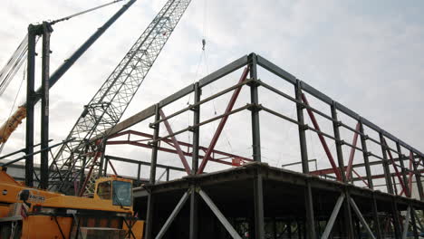 steel frame building structure under construction with a large crane