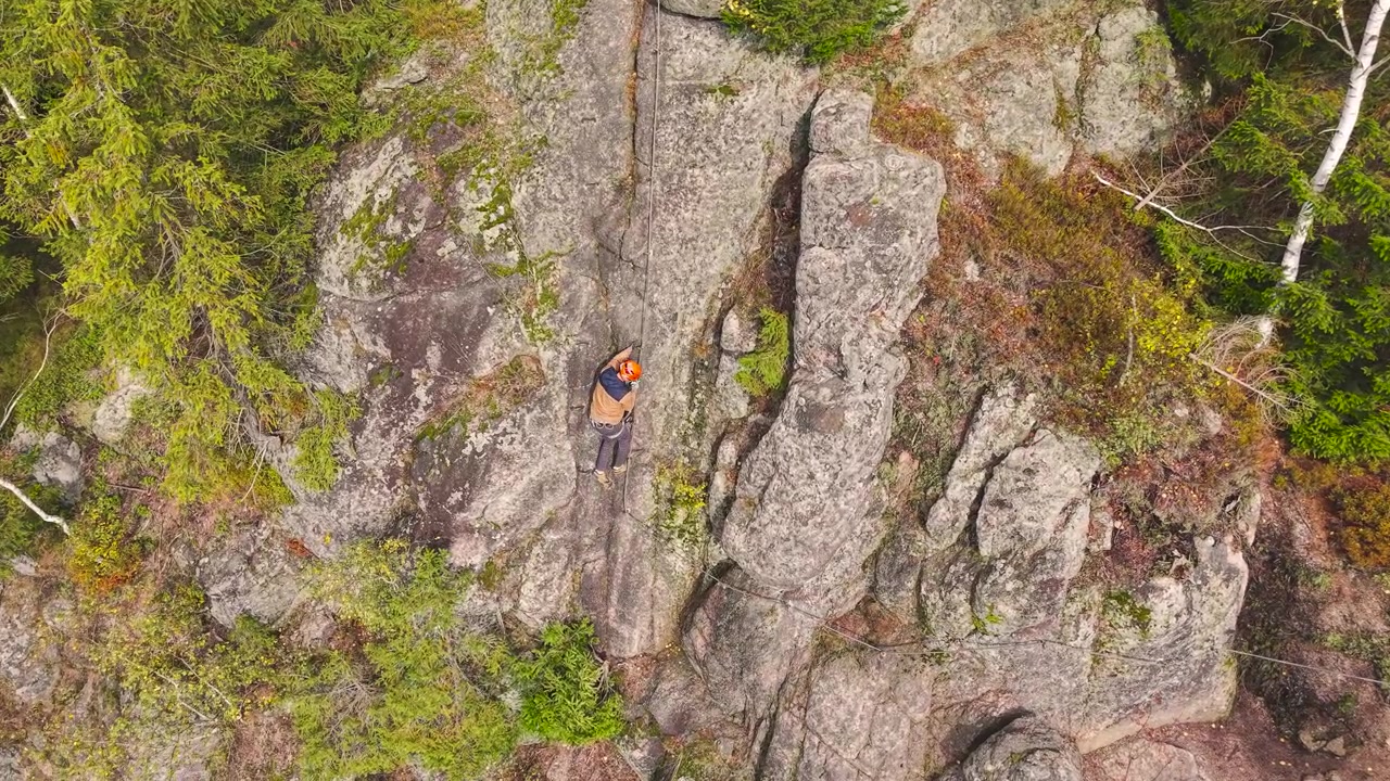 Aerial - person climb steep mountain wall using equipment, Czech Republic