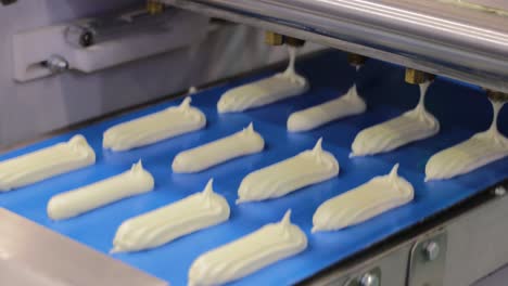 Cakes-on-automatic-conveyor-belt-,-process-of-baking-in-confectionery-factory.