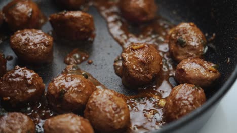 unrecognizable person cooking green beans and meatballs