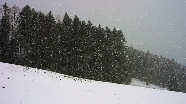 Neve che cade al rallentatore sulle montagne.