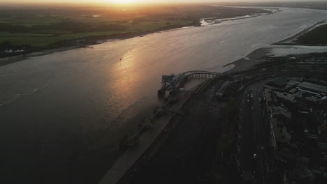 Slow-motion-derelict-dockland-sunrise-approach-with-sunlit-river-at-fishing-port-Fleetwood