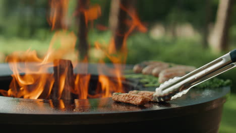 外でグリルでbbq肉を調理する男性