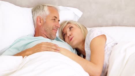 Couple-chatting-in-bed-and-cuddling