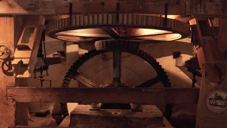 close up on a section of an interior gear mechanism of a water mill, composed by two cogwheels working together to creat movement to grind cereals into flour