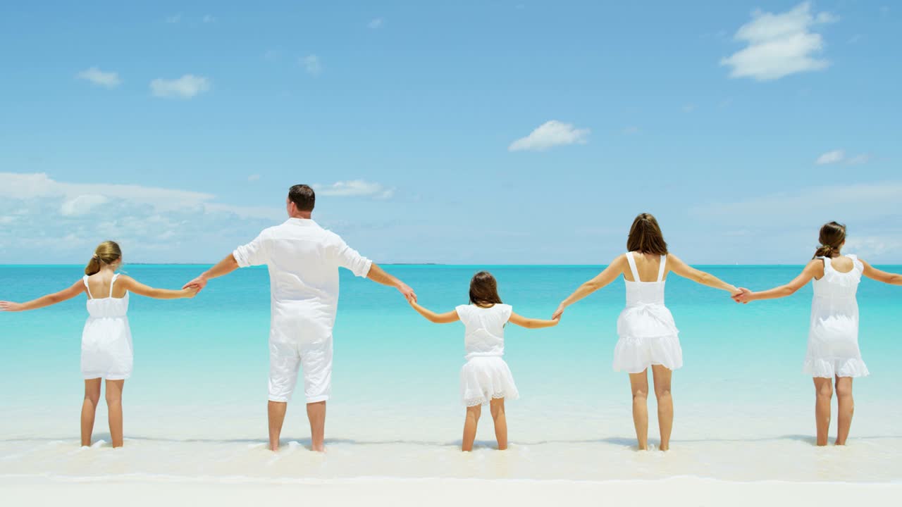 카우카시안 가족은 열대 바다의 해변에서 함께합니다.