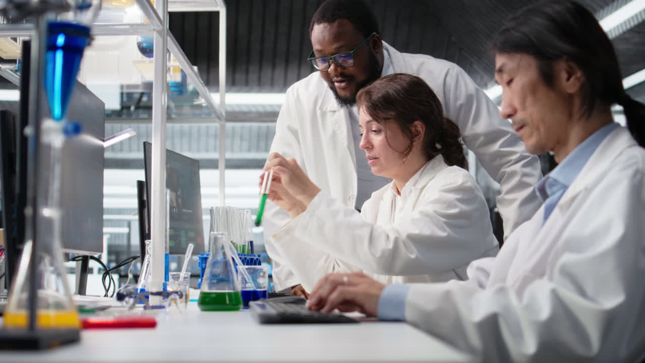 Vertical video Multiethnic research facility team using colorful chemical solutions