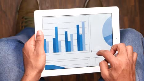 persona que utiliza una tableta con gráficos y gráficos