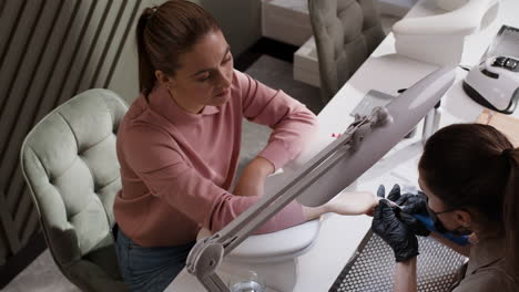 woman getting a manicure at a nail salon