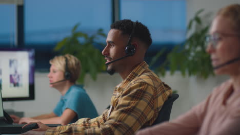 business team wearing headsets working late at customer support centre