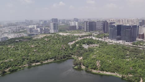 deforestation in a city is depicted in cinematic aerial footage with green groves and skyscrapers