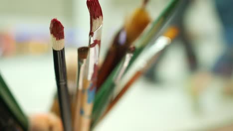 close up of art brush in a mug on table