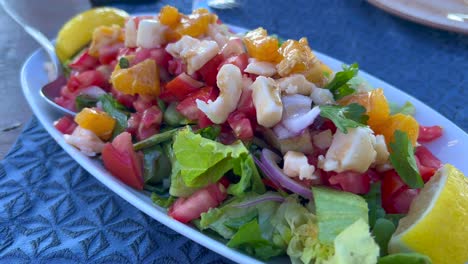 delicious and healthy salad with feta cheese, tomatoes, lettuce, onion, orange and lemons, tasty lunch, 4k shot