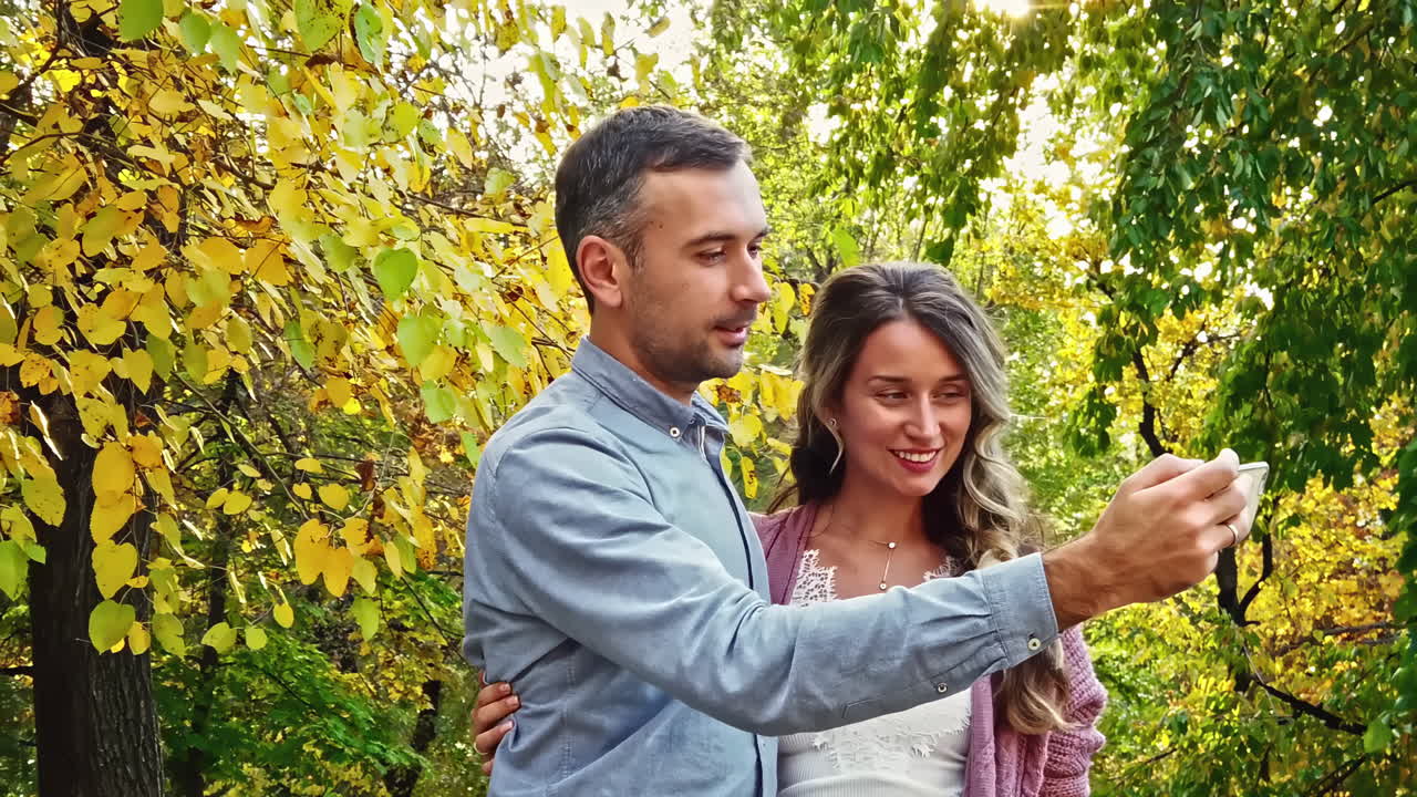 Coppia che si fa un selfie in un parco autunnale
