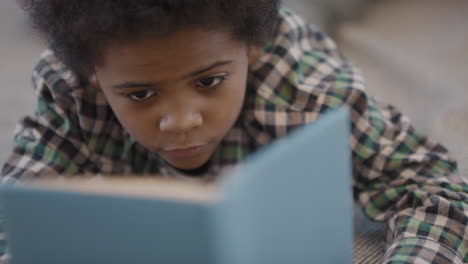 close up of afro boy reading