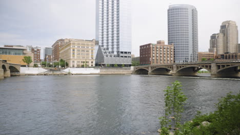 handheld panning shot of a river flowing through a downtown urban environment