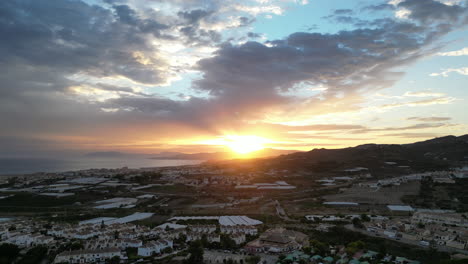 Hermosa-Puesta-De-Sol-Tomada-Desde-Un-Dron-Que-Se-Eleva-Sobre-El-Campo-Español-Con-Nubes-Sobre-El-Mar