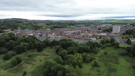 rising drone shot of county durham town centre, bishop auckland surrounded by fields - uk